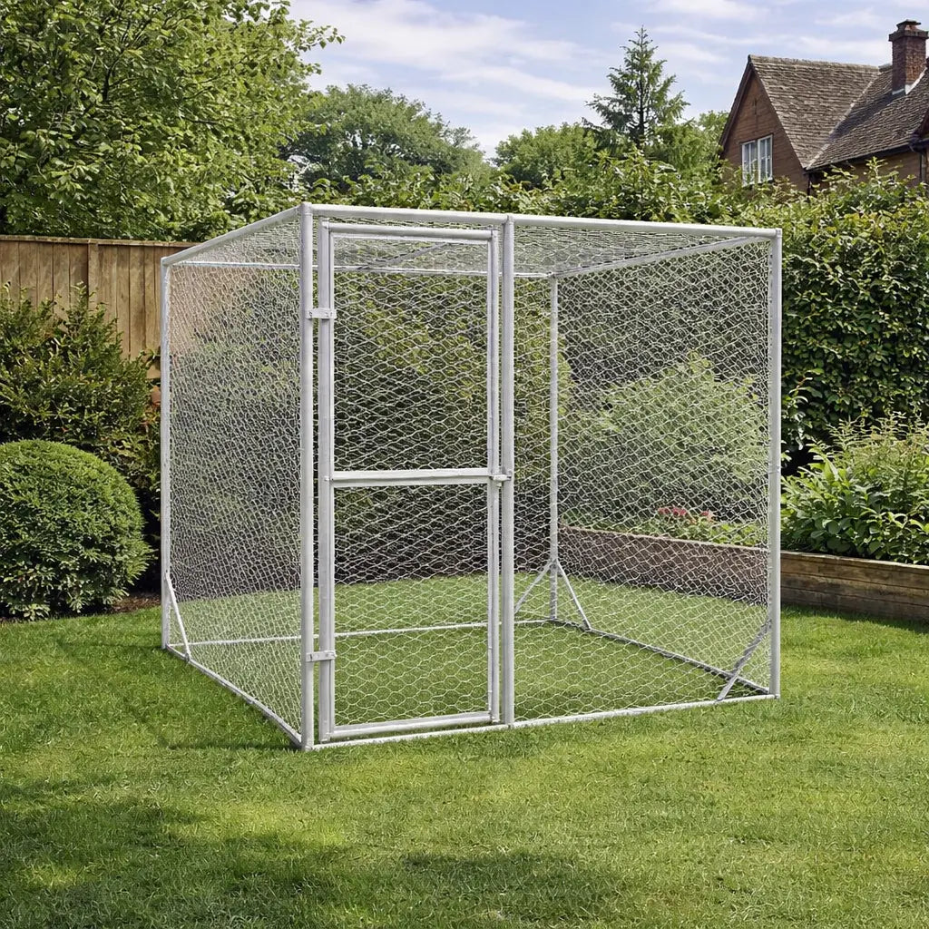 Compact galvanised steel dog run placed on a lawn in a garden with fencing and trees behind