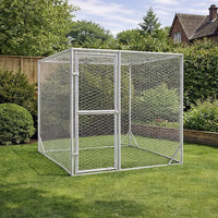 Compact galvanised steel dog run placed on a lawn in a garden with fencing and trees behind